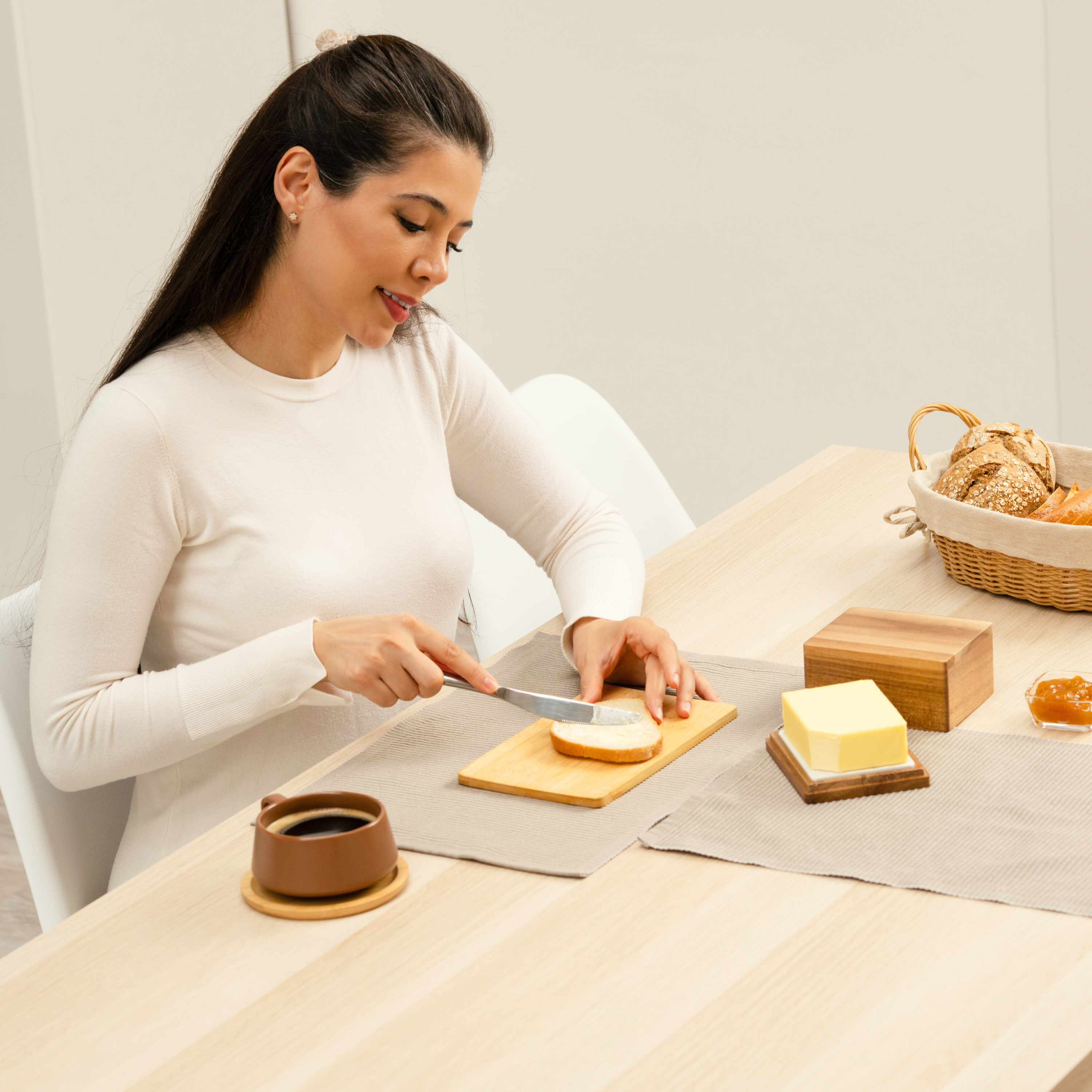 CALIDORO Butterbehälter beim Frühstück in einer hellen Küche. Eine Frau streicht Butter auf ein Stück Brot.